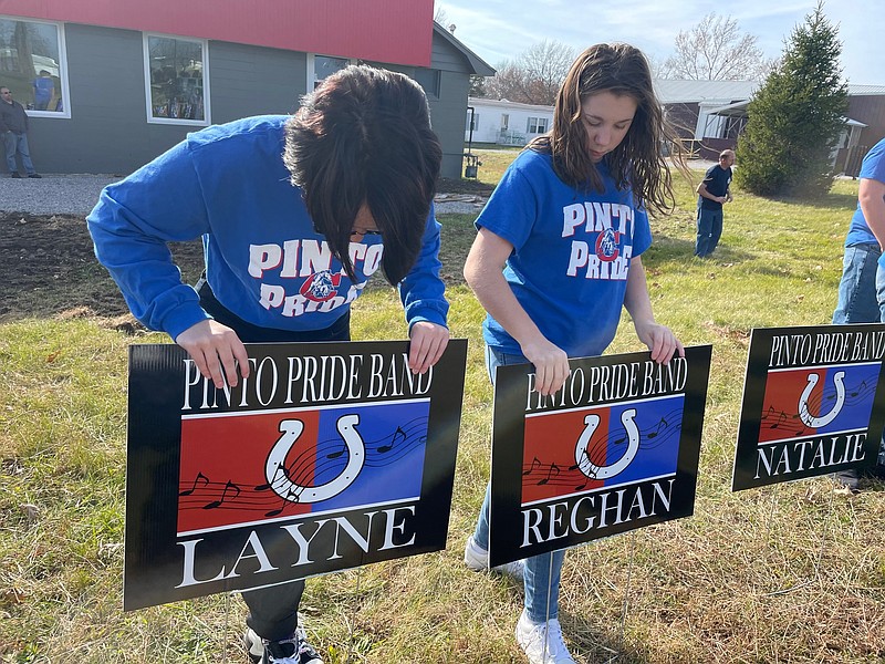 Democrat photo/Kaden Quinn 
Pinto Pride Marching Band members place their personalized signs into the ground last week. The California Eagles donated the signs, aiming to lend more recognition to the group.
