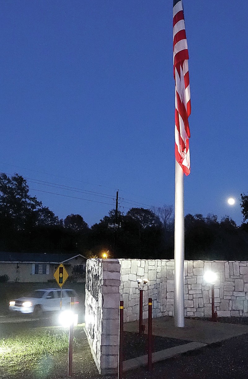 Somewhere in Cass County is this beautifully displayed and lighted American flag. It was raised, lighted and is cared for by volunteers, some of whom are teenagers. This display lights up an entire community because it is connected to an activity that’s voluntary but necessary. In this photograph, the moon is rising at lower right. Do you know where and why it is? Return to Regional News next week. (Staff photo by Neil Abeles)