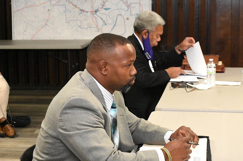 Fired Pine Bluff Police Detective Christopher Sweeny, in foreground, waits for the start of his appeals hearing as interim Pine Bluff Police Chief Lloyd Franklin Sr. reviews notes Friday, Nov. 20, 2021, at the city council chambers. (Pine Bluff Commercial/I.C. Murrell)