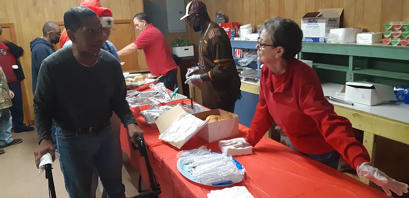 Billie Shaddix, a volunteer for Texas Special Children's Projects since 2010, helps serve Tuesday's Christmas dinner for participants. Texas Special Children's Project does this every year, only skipping 2020 because of COVID. Even then, they made arrangements to visit their community members, bringing gifts and Christmas cheer. (Staff photo by Junius Stone