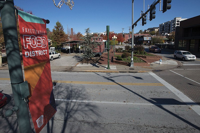 The northwest corner of West Ave. and Dickson Street in Fayetteville, seen here Nov. 11, 2021, is the site of a planned parking deck. (File photo/NWA Democrat-Gazette/J.T. Wampler)