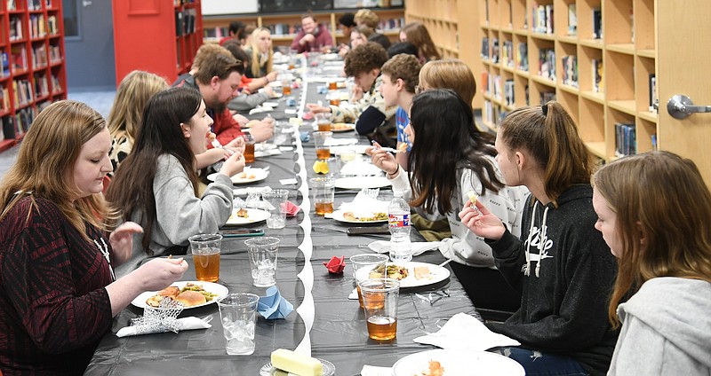 Breann Johnston, Cutter Morning Star High School world history teacher, front, left, sits with her students in the library for their "enlightened thinkers" party on Thursday. - Photo by Tanner Newton of The Sentinel-Record