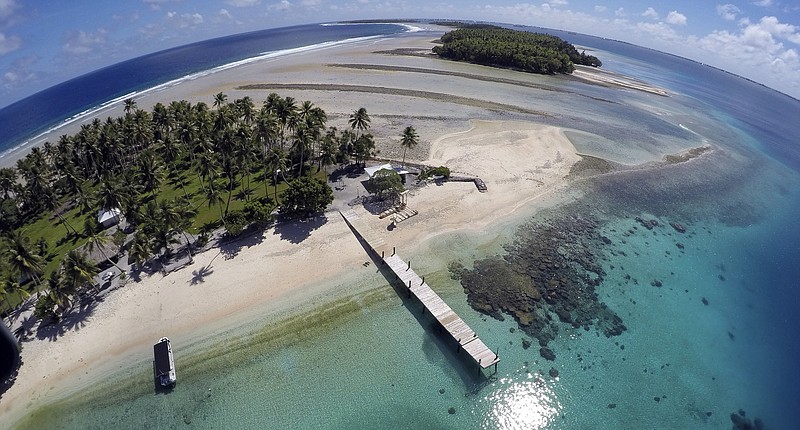 FILE - An aerial photo shows a small section of the atoll that has slipped beneath the water line only showing a small pile of rocks at low tide on Majuro Atoll in the Marshall Islands on Nov. 8, 2015. For decades, the tiny Marshall Islands has been a stalwart American ally. Its location in the middle of the Pacific Ocean has made it a key strategic outpost for the U.S. military. (AP Photo/Rob Griffith, File)