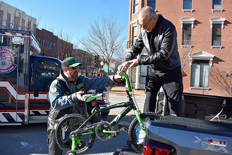 Gerry Tritz/News Tribune
Darron &quot;Cooter&quot; Blakemore, left, hands a bike to Frank Livingston, assistant coordinator of the local Toys for Tots campaign. The bike was part one of hundreds of toys donated by county employees. Blakemore is a member of The Hooligans, a motorcycle club that works to help children in need. One of the club members works for Cole County's Public Works Department.