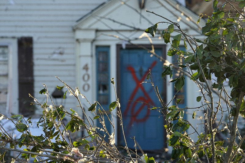 Search and rescue markings are seen painted on the door of a destroyed home in the aftermath of tornadoes that tore through the region, in Mayfield, Ky., Monday, Dec. 13, 2021. (AP Photo/Gerald Herbert)