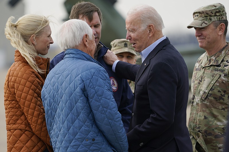 President Joe Biden greets former Gov. Steve Beshear, second from left, Kentucky Gov. Andy Beshear, third from left, and his wife Britainy Beshear, left, as he arrives in Fort Campbell, Ky., Wednesday, Dec. 15, 2021, to survey storm damage from tornadoes and extreme weather. (AP Photo/Andrew Harnik)