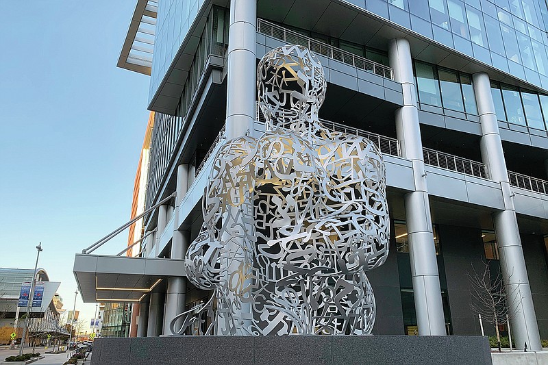 A 16-foot sculpture by Spanish artist Jaume Plensa was installed in downtown Grand Rapids, Mich.,Friday, Nov. 19, 2021. The 5,400-pound sculpture uses letters and element symbols for air, water, fire and earth to form a human figure. It's meant to signify &quot;the many different characteristics that bring people together to form a single human race,&quot; according to a news release. Plensa has created projects displayed publicly in cities like Chicago, San Diego, Seattle, Miami, Montreal, London, Dubai, Bangkok, Shanghai and Tokyo. (Rose White/The Grand Rapids Press via AP)
