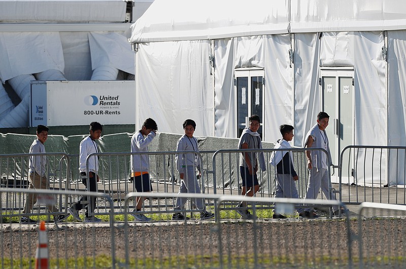 FILE - In this Feb. 19, 2019 photo, youngsters line up to enter a tent at the Homestead Temporary Shelter for Unaccompanied Children in Homestead, Fla. The American Civil Liberties Union says the Department of Justice has withdrawn from talks to settle lawsuits filed on behalf of parents and children who were separated under the Trump administration's zero-tolerance border enforcement policy.(AP Photo/Wilfredo Lee, File)