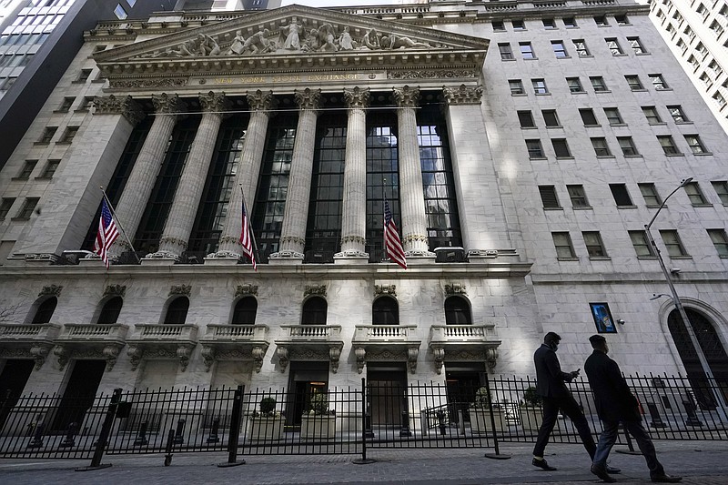 FILE - Pedestrians walk past the New York Stock Exchange in New York's Financial District, on March 23, 2021.  Technology stocks are leading another decline on Wall Street in early trading Friday, Dec. 17, putting the Nasdaq on track for its third weekly drop in the last four. (AP Photo/Mary Altaffer, File)