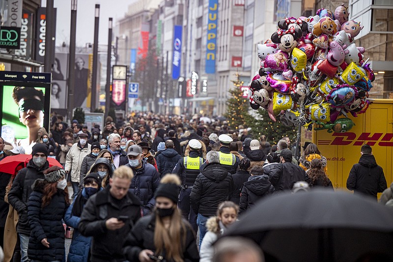 Despite rainy weather, Duesseldorf's city centre is well frequented despite the Corona rules for retailers, shortly before Christmas in Duesseldorf, Germany, Saturday, Dec. 18, 2021. (Malte Krudewig/dpa via AP)