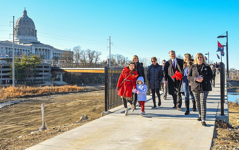 Members of Betty Jo DeLong's family were joined by Jefferson City Mayor Carrie Tergin, at left, and her niece as they step off of the Bicentennial Bridge onto Adrian's Island Monday, Dec. 20, 2021, following dedication and ribbon cutting ceremonies near the south entrance of the bridge.