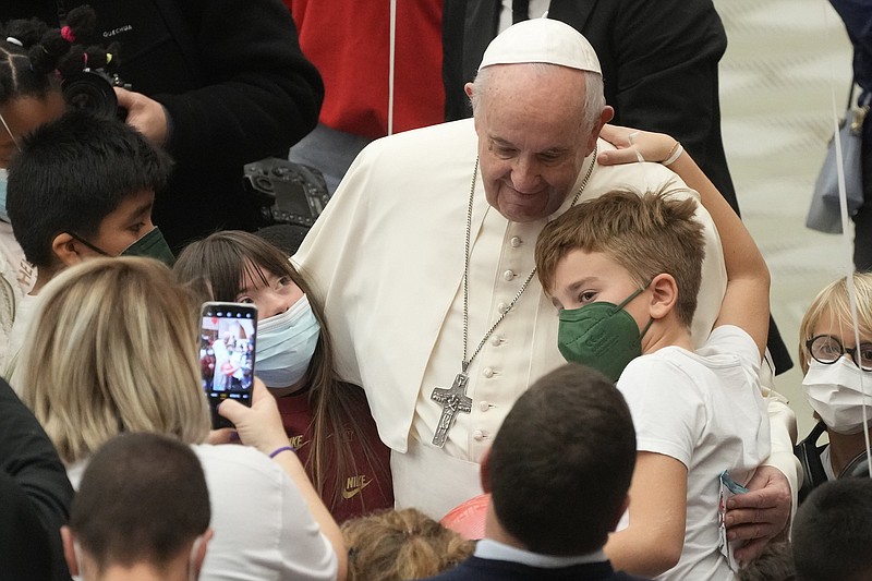 FILE - Pope Francis meets with children assisted by Santa Marta dispensary in the Paul VI Hall, at the Vatican, Sunday, Dec. 19, 2021. Pope Francis has denounced domestic violence against woman as ?nearly satanic? and said parents should never slap their children.  (AP Photo/Gregorio Borgia, File)