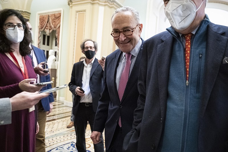 Senate Majority Leader Chuck Schumer, D-N.Y., and Sen. Sheldon Whitehouse, D-R.I., head to the Senate floor after a Democratic policy luncheon on Capitol Hill on Dec. 17, 2021 in Washington. MUST CREDIT: Washington Post photo by Jabin Botsford