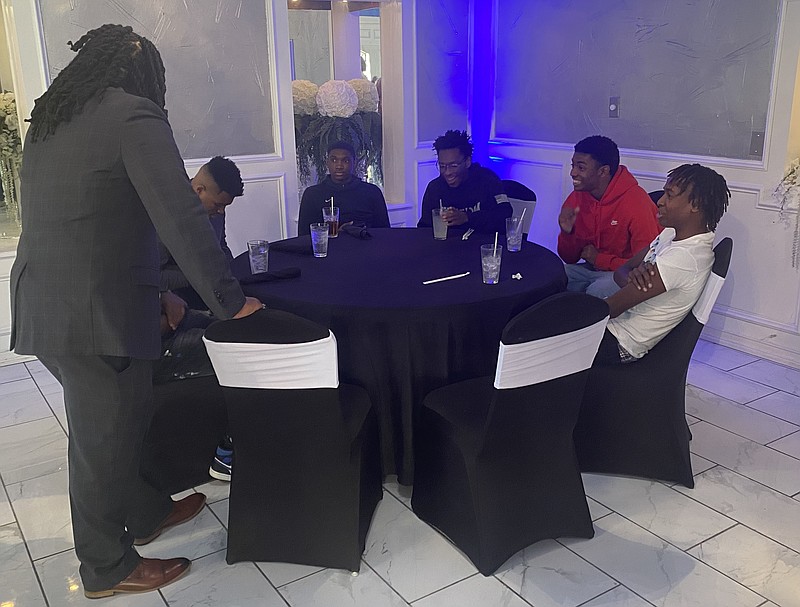 Brighter Tomorrow Foundation Director Johnathon Boyce, far left, speaks to members of the Liberty-Eylau High boys basketball team at the Dapper restaurant. (Staff Photo by Andrew Bell)