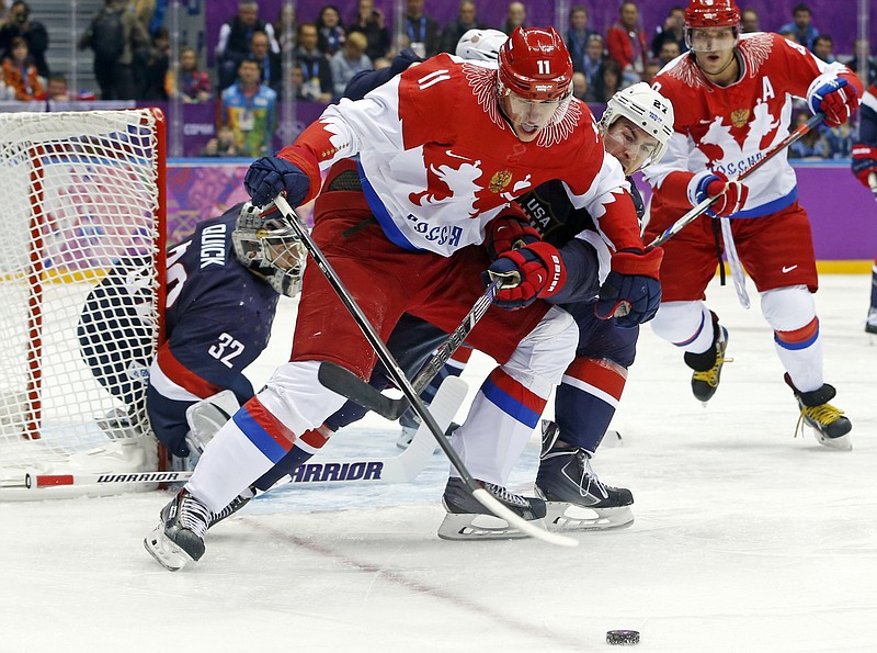FILE -Russia forward Yevgeni Malkin seals off the puck from USA defenseman Ryan McDonagh in the first period of a men's ice hockey game at the 2014 Winter Olympics, Saturday, Feb. 15, 2014, in Sochi, Russia. NHL players will not take part in the upcoming Winter Olympics in Beijing after all. A person with direct knowledge of the decision tells The Associated Press the league is going to withdraw from the Olympics after the regular-season schedule was disrupted by coronavirus outbreaks, Tuesday, Dec. 21, 2021. (AP Photo/Mark Humphrey, File)