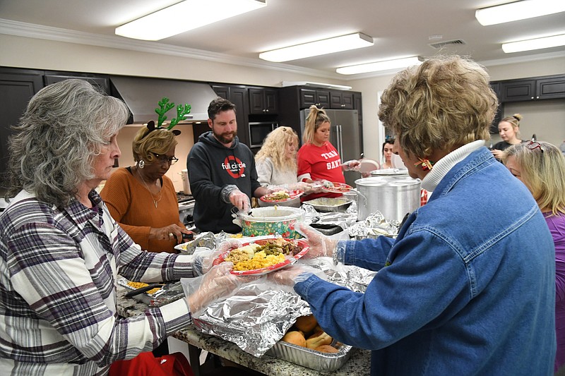 Volunteers get ready to serve Christmas meals to the homeless at Lakeview Assembly Church for its annual Christmas party. - Photo by Tanner Newton of The Sentinel-Record