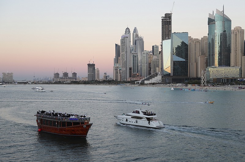 Tourists enjoy on a yacht as they pass a traditional dhow serving a dinner cruise, in Dubai, United Arab Emirates, Jan. 12. The globalized city-state of Dubai appears to be in the midst of a boom season. It's a surge in growth spurred on by one of the world’s highest vaccination rates and government moves to de-escalate tensions with regional rivals and lure foreign businesses. - AP Photo/Kamran Jebreili