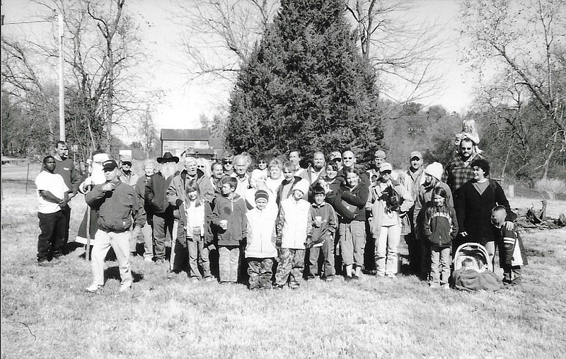 Canehill residents gather in 2008 to celebrate the purchase and planting of the town&#xd5;s live Christmas tree. According to the tree&#xd5;s donor, the hole for the tree was deemed too big by the company that planted it, but a truck carrying a backhoe broke down nearby allowing for it to be set into place. Visit nwaonline.com/211223Daily/ for today's photo gallery.
(COURTESY PHOTO)