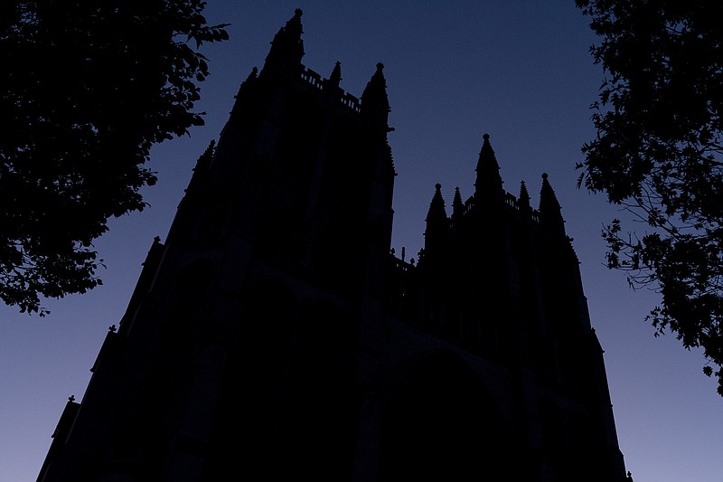 FILE - The Washington National Cathedral is seen at dawn in Washington on Friday, Nov. 5, 2021. Amid the surge of coronavirus cases across the U.S., this and many other churches have cancelled in-person Christmas services, disappointing pastors and churchgoers who consider them an annual highlight. (AP Photo/Andrew Harnik)