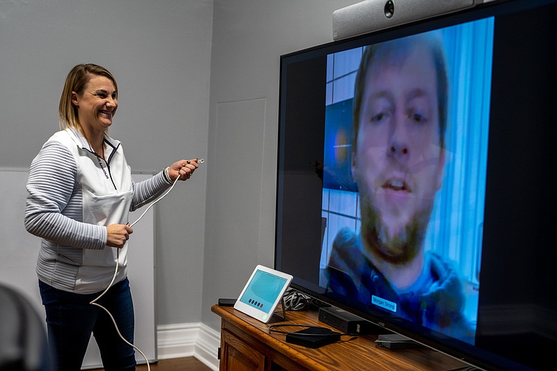 Ethan Weston/News Tribune Victoria Jansen laughs as Morgan Strong tests a conference room monitor on Thursday, Dec. 30, 2021 at the Missouri State Capitol Building in Jefferson City, Mo. The pair work IT and were getting the conference room set up.