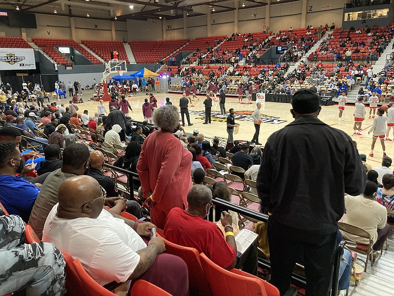 Fans stand and stretch as players warm up to play on Monday at the King Cotton tournament at the Pine Bluff Convention Center. (Pine Bluff Commercial/Byron Tate)