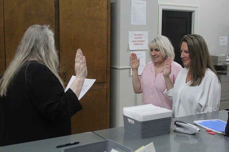 Union County Clerk Shannon Phillips, facing away, swears in Parkers Chapel School Board members Lisa Murray, left, and Kris Madison on Monday, May 24. Murray and Madison both bested incumbent school board candidates in the 2021 school board elections. (News-Times file)
