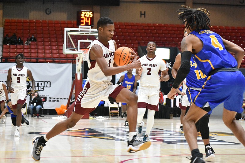 Cedric Adams of Pine Bluff dribbles past Chris Fuqua of Raymond in the first quarter Wednesday, Dec. 29, 2021, at the Pine Bluff Convention Center. (Pine Bluff Commercial/I.C. Murrell)