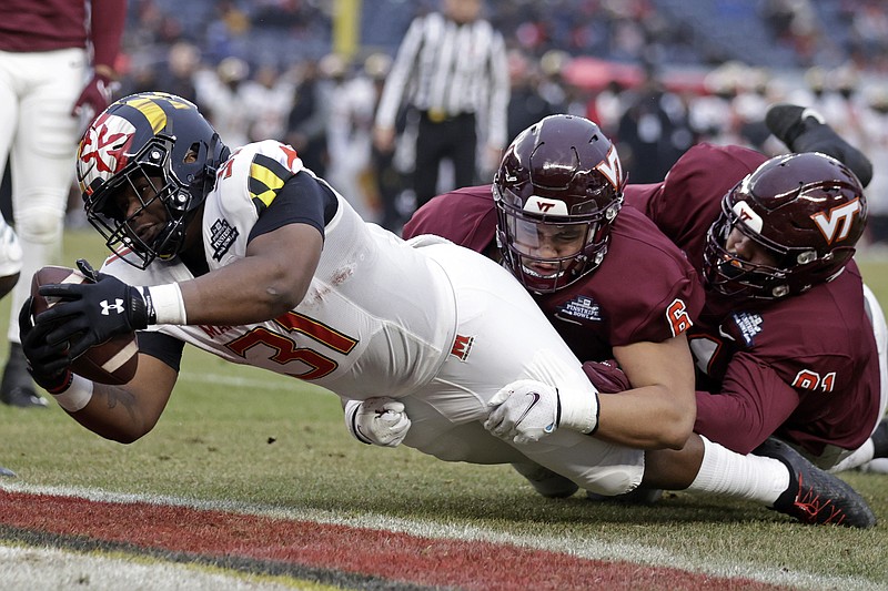 Maryland running back Antwaine Littleton II (31) scores a touchdown past Virginia Tech defensive lineman Josh Fuga (6) during the first half of the Pinstripe Bowl NCAA college football game in New York, Wednesday, Dec. 29, 2021. (AP Photo/Adam Hunger)