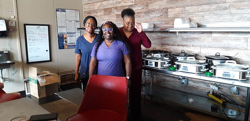 The women of Big Mama's Crockpot serve it up on 9th Street. Citing generations of cooking tradition, the ladies ladle up steaming goodness. Tracy Hildrath, right, Heather Batts and Sharon Batts continue a tradition of homestyle cooking. (Staff photo by Junius Stone)