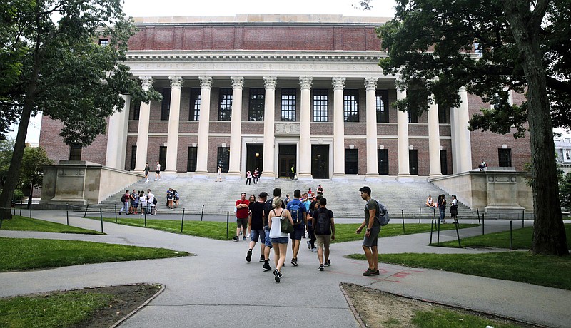 FILE - Students walk near the Widener Library at Harvard University in Cambridge, Mass., Aug. 13, 2019. Harvard University is telling students to take classes from home for three weeks, with a return to campus scheduled for late January, &quot;conditions permitting.&quot; (AP Photo/Charles Krupa, File)