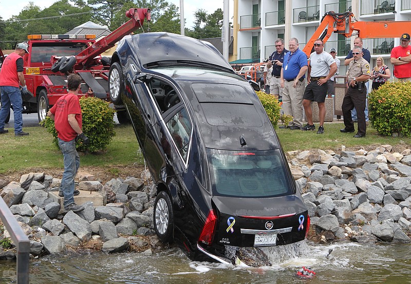 Members of the Garland County Sheriff's Department watch as wrecker service employees remove a Cadillac from Lake Hamilton on May 16, 2011. - File photo by The Sentinel-Record