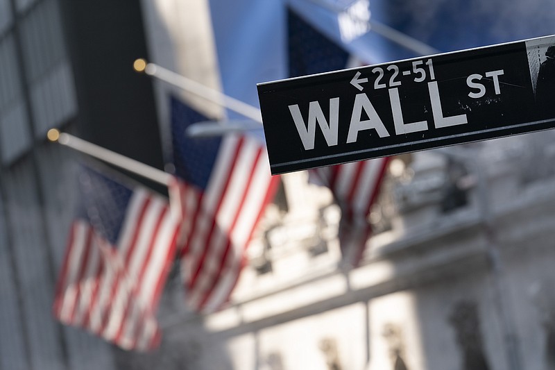 FILE - A sign for Wall Street hangs in front of the New York Stock Exchange, July 8, 2021. Stocks are off to a mostly higher start on Wall Street, Tuesday, Jan. 4, 2022 as traders gear up for economic reports and company earnings to resume after the year-end holidays. (AP Photo/Mark Lennihan, file)