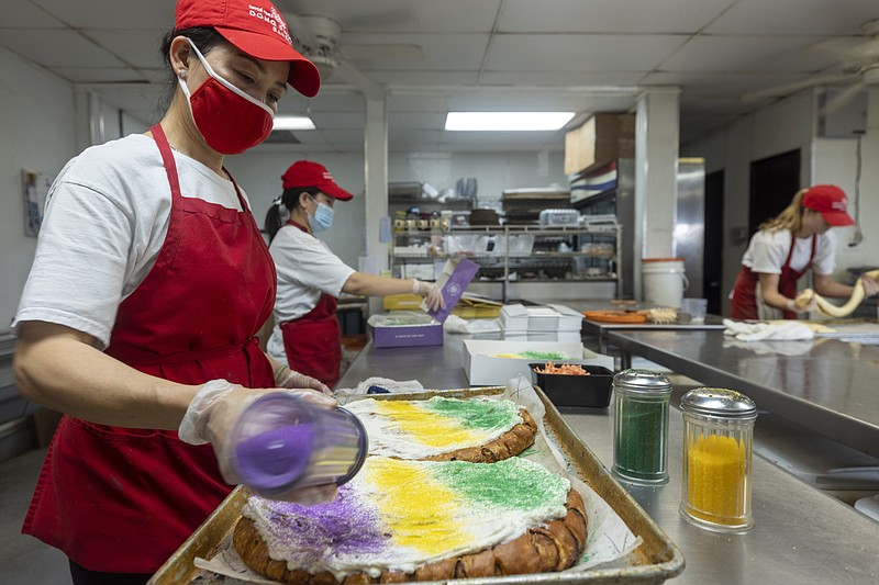 King cakes are decorated at Dong Phuong Bakery in eastern New Orleans. The colorful cake is more than a dessert — it’s the flavor of the New Orleans — and a diverse community of bakers are adapting the Carnival specialty to their own tastes. (The New York Times/L. Kasimu Harris)