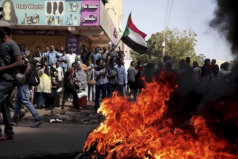 People chant slogans and burn tires during a protest to denounce the October 2021 military coup, in Khartoum, Sudan, Thursday, Jan. 6, 2022. Sudanese took to the streets in the capital, Khartoum, and other cities on Thursday in anti-coup protests as the country plunged further into turmoil following the resignation of the prime minister earlier this week. (AP Photo/Marwan Ali)