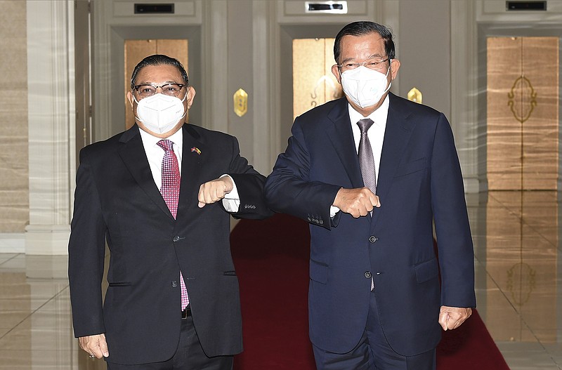 FILE - In this photo provided by An Khoun Sam Aun/National Television of Cambodia, Cambodian Prime Minister Hun Sen, right, greets with Myanmar Foreign Minister Wunna Maung Lwin at Peace Palace in Phnom Penh, Cambodia on Dec. 7, 2021. Prime Minister Hun Sen begins a visit to strife-torn Myanmar on Friday, Jan. 7,  that he hopes will invigorate efforts by Southeast Asian nations to start a peace process, but critics say will legitimize the rule of the military that took power last year and its campaign of violence.   (An Khoun SamAun/National Television of Cambodia via AP, File)