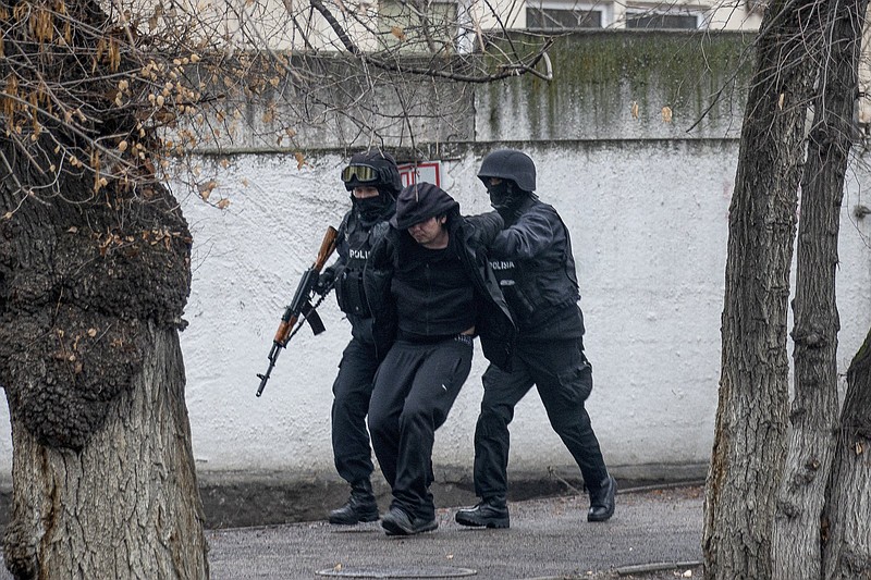 Armed riot police officers detain a protester during a security anti-terrorists operation in a street after clashes in Almaty, Kazakhstan, Saturday, Jan. 8, 2022. Kazakhstan's president authorized security forces on Friday to shoot to kill those participating in unrest, opening the door for a dramatic escalation in a crackdown on anti-government protests that have turned violent. The Central Asian nation this week experienced its worst street protests since gaining independence from the Soviet Union three decades ago, and dozens have been killed in the tumult.(AP Photo/Vasily Krestyaninov)