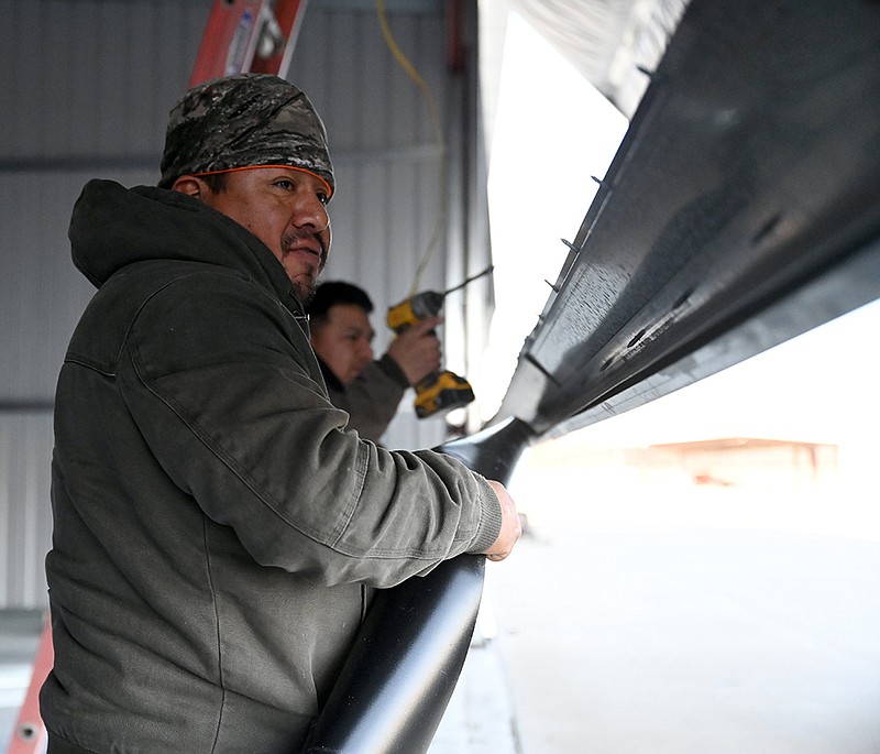 Pedro Orvera works on installing insulation on the bottom of a hangar door during construction of a new T-Hangar at Conway Regional Airport on Friday, Jan. 7, 2022. The hangar currently has a wait list of over 40 aircraft owners hoping to rent one of the 12 new spaces it will provide, said Conway Airport director Jack Bell.

(Arkansas Democrat-Gazette/Stephen Swofford)