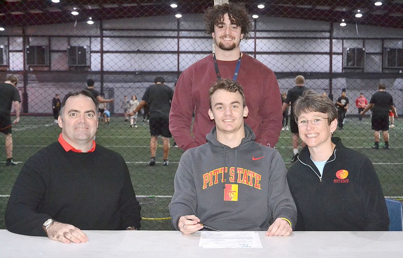 Patrick Elliott, center, was joined by his parents, Dean and Sara Elliott, and brother, Cooper Elliott, to celebrate his signing a letter of intent to run track at Pittsburg State, Kansas. He plans to major in kinestheology, physical therapy. &quot;Probably go into the medical field and help others because I really like helping other people. It makes me feel good,&quot; Patrick said.