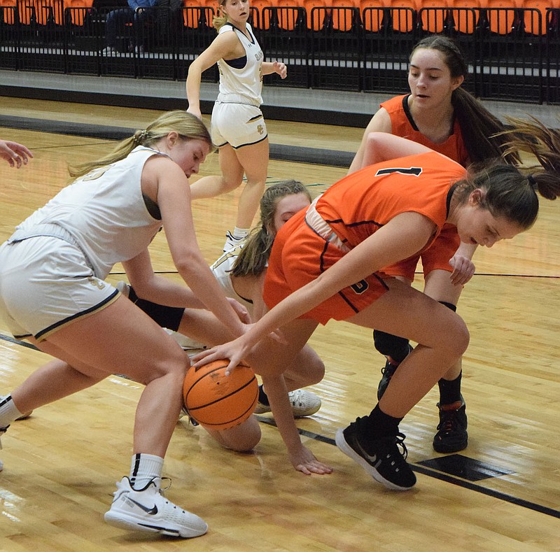 Westside Eagle Observer/MIKE ECKELS
A real mess on the floor as DaLacie Wishon (Gravette 1) reaches behind her to steal the ball away from a Lady Saint player as a second Lady Saint falls on Wishon's left leg, knocking her to the floor. The melee took place in the third quarter of the Gravette-Shiloh Christian conference contest at the Lions' Den in Gravette Jan. 11.