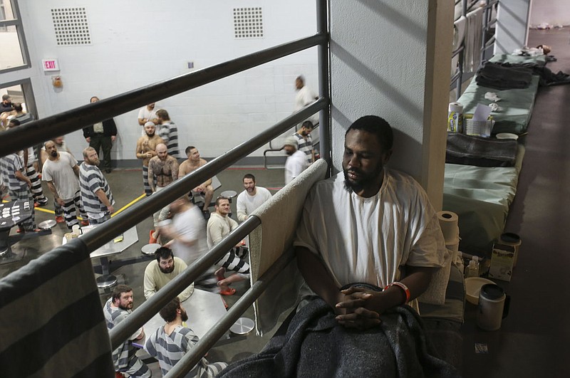 Jamon Carter sits on his bed mat that is set up along an overflow bunking area near a walkway railing, Monday, January 10, 2022 at the Washington County Detention Center in Fayetteville. Check out nwaonline.com/220111Daily/ for today's photo gallery. 
(NWA Democrat-Gazette/Charlie Kaijo)
