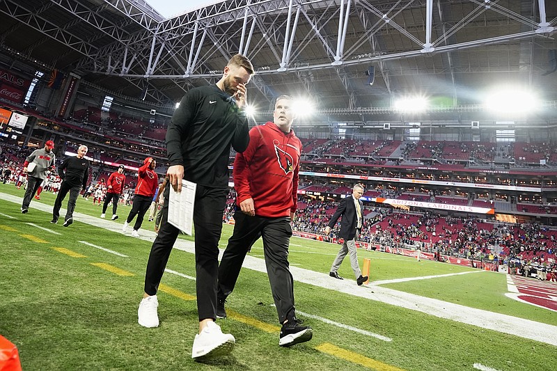 Arizona Cardinals head coach Kliff Kingsbury, left, walks off the field after an NFL football game loss to the Seattle Seahawks Sunday, Jan. 9, 2022, in Glendale, Ariz. The Seahawks won 38-30. (AP Photo/Darryl Webb)