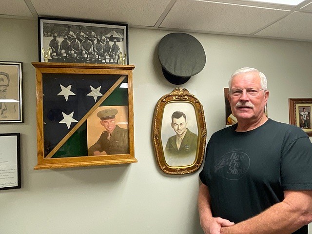 Kelly Odneal Jr. stands proudly with his father's portrait and possessions he had discovered when learning more about his service. (Democrat photo/Kaden Quinn)