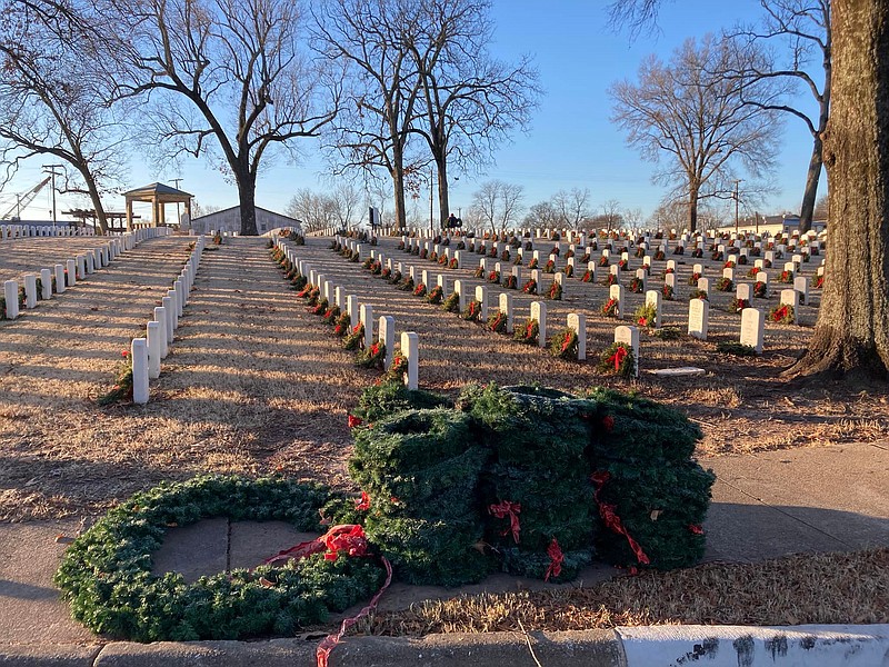 The United States Daughters of 1812 and other volunteers, including the Arkansas National Guard, pick up nearly 3,000 wreaths from the graves of unknown soldiers after the Christmas holidays at Little Rock National Cemetery. The wreaths were carried to the curbs and then loaded into a truck by the National Guard for storage until next Christmas. - Photos courtesy of Pat McLemore and Randall Freeman. - Submitted photo