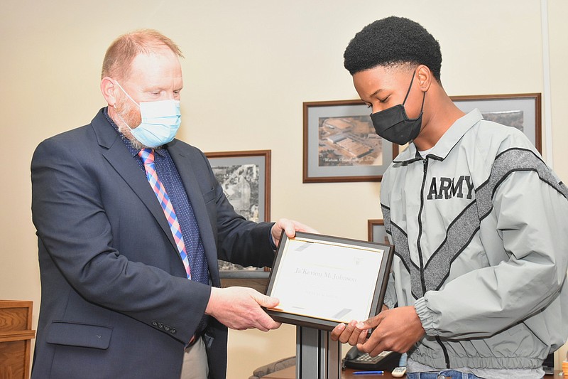 Watson Chapel School District Superintendent Andrew Curry presents eighth-grader Ja'Kevion Johnson with his framed Wildcat Warrior certificate during a school board meeting Monday, Jan. 10, 2022. (Pine Bluff Commercial/I.C. Murrell)