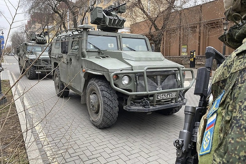 In this photo released by the Russian Defense Ministry Press Service, Russian peacekeepers of the Collective Security Treaty Organization park their military vehicles to guard an area in Almaty, Kazakhstan, Tuesday, Jan. 11, 2022. The president of Kazakhstan has announced that a Russia-led security alliance will start pulling out its troops from the Central Asian country in two days after completing its mission. The mostly Russian troops were deployed to Kazakhstan last week by the Collective Security Treaty Organization, an alliance of six former Soviet states, at the president's request amid unprecedented public unrest. (Russian Defense Ministry Press Service via AP)