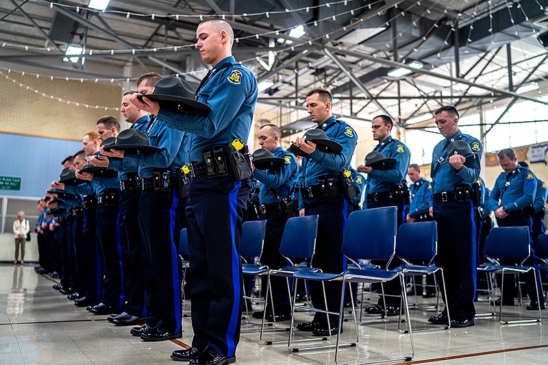 New members of the Missouri Highway Patrol remove their hats and bow their heads in prayer Wednesday during their graduation ceremony at the MSHP General Headquarters in Jefferson City. The officers were part of the 112th class. (Ethan Weston/News Tribune)