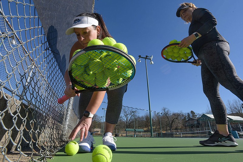 Alia Lyle (left) and Diane Smith retrieve tennis balls during a coaching session with Director of Tennis for the Western Arkansas Tennis Association Brian Pillar (not pictured) on Thursday, Jan. 13, 2022, at the Creekmore Park Tennis Center in Fort Smith. The Fort Smith Parks Commission recently approved a proposal to renew the lease agreement with WATA at the Creekmore Park Tennis Center for three years. Visit nwaonline.com/220116Daily/ for today's photo gallery.
(NWA Democrat-Gazette/Hank Layton)