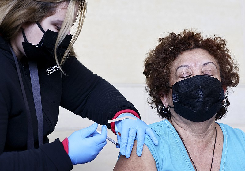 A person receives a COVID-19 vaccination dose, during a free distribution of COVID-19 rapid test kits for those who received vaccination shots or booster shots, at Union Station on Jan. 7, 2022, in Los Angeles, California. (Mario Tama/Getty Images/TNS)