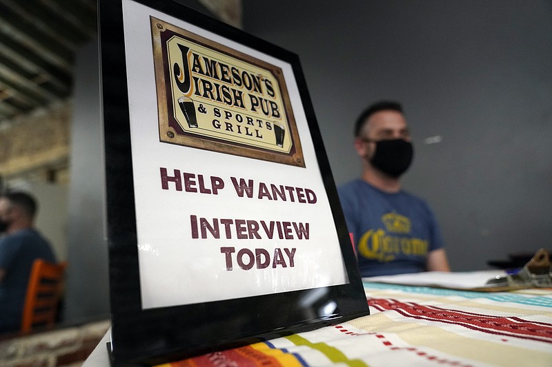 FILE - A hiring sign is shown at a booth for Jameson's Irish Pub during a job fair on Sept. 22, 2021, in the West Hollywood section of Los Angeles. Hiring in California slowed significantly in November 2021 even as the state's unemployment rate dipped below 7% for the first time since March 2020, at the start of the pandemic, according to data made public Friday, Dec. 17, 2021. (AP Photo/Marcio Jose Sanchez, File)