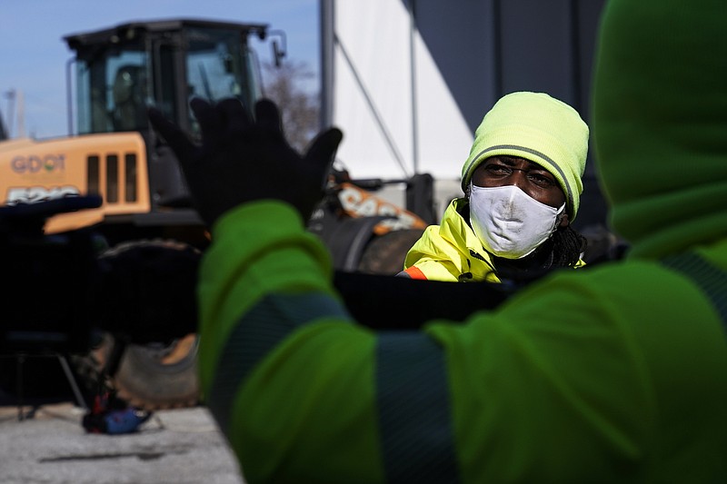 A Georgia Department of Transportation response member looks at a brine truck tank being filled ahead of a winter storm at the GDOT's Maintenance Activities Unit location on Friday, Jan. 14, 2022, in Forest Park, Ga. A winter storm is headed south that could effect much of Georgia through Sunday. (AP Photo/Brynn Anderson)